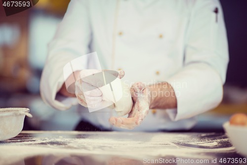 Image of chef hands preparing dough for pizza