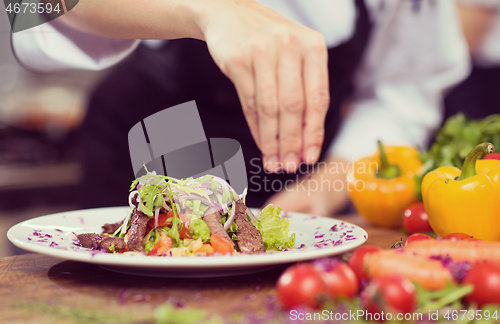 Image of cook chef decorating garnishing prepared meal