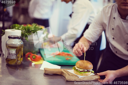 Image of chef finishing burger