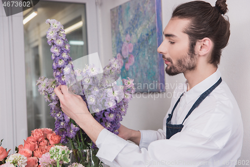 Image of Small business. Male florist in flower shop. Floral design studio, making decorations and arrangements.