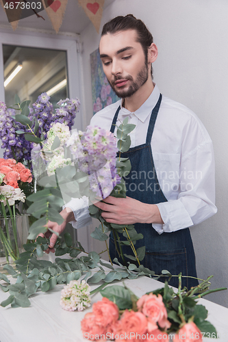 Image of Small business. Male florist in flower shop. Floral design studio, making decorations and arrangements.