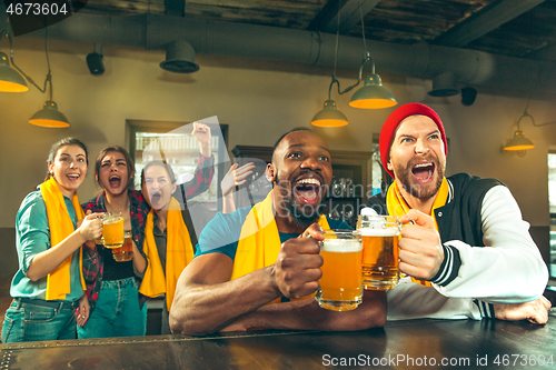 Image of Sport, people, leisure, friendship and entertainment concept - happy football fans or male friends drinking beer and celebrating victory at bar or pub