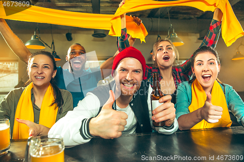 Image of Sport, people, leisure, friendship and entertainment concept - happy football fans or male friends drinking beer and celebrating victory at bar or pub