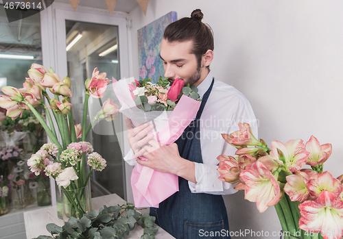 Image of Small business. Male florist in flower shop. Floral design studio, making decorations and arrangements.