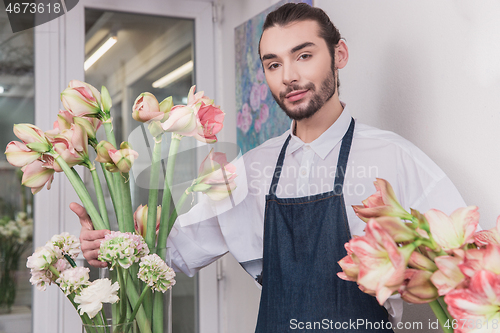 Image of Small business. Male florist in flower shop. Floral design studio, making decorations and arrangements.