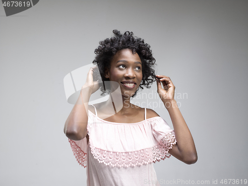 Image of The happy african woman standing and smiling against red background.