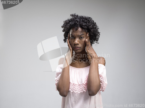 Image of Woman having headache. Isolated over gray background.