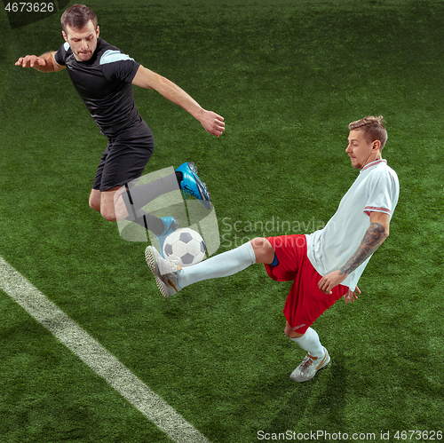 Image of Football players tackling ball over green grass background