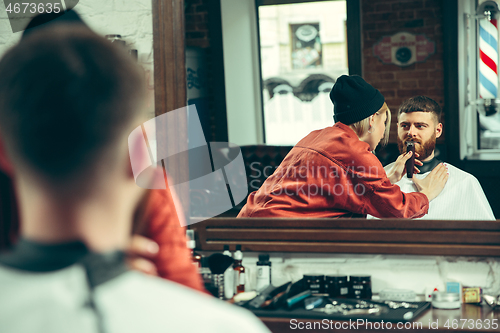 Image of Client during beard shaving in barber shop