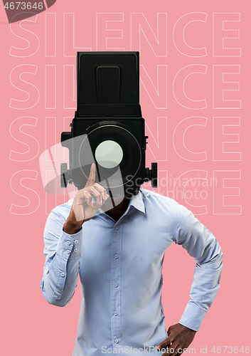 Image of Studio portrait of young man covering his mouth - speak no evil concept