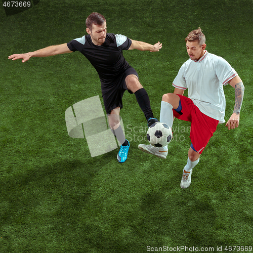 Image of Football players tackling ball over green grass background