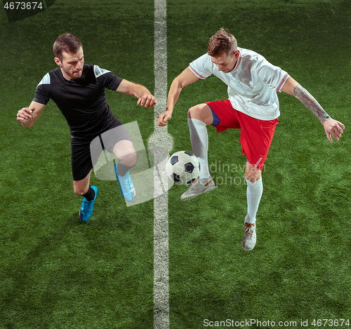 Image of Football players tackling ball over green grass background