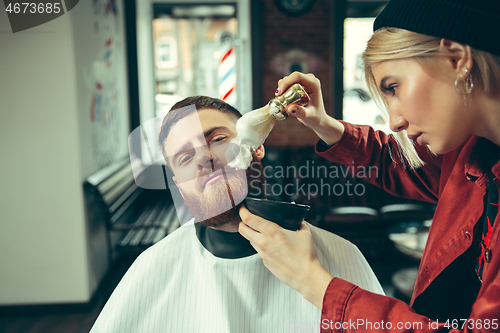 Image of Client during beard shaving in barber shop