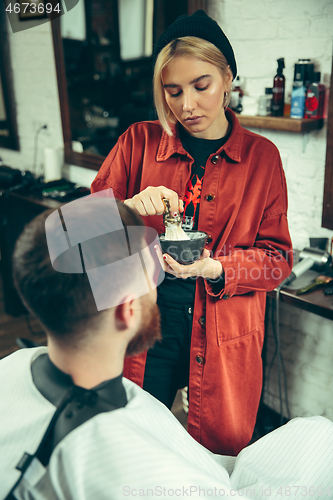 Image of Client during beard shaving in barber shop