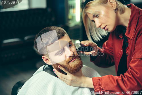 Image of Client during beard shaving in barber shop