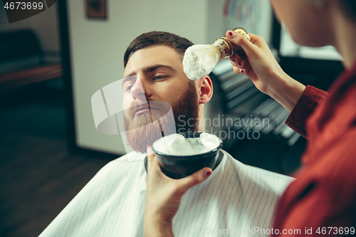 Image of Client during beard shaving in barber shop