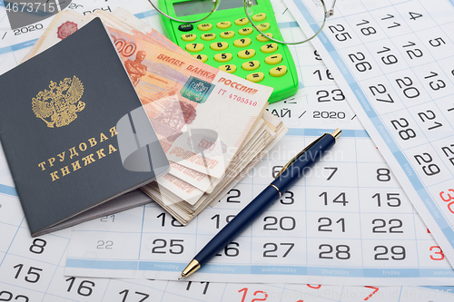 Image of Labor retirement savings, work book, calendar, pen and glasses on calendar background