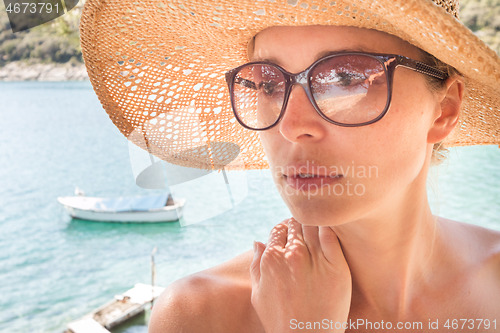 Image of Close up portrait of no makeup natural beautiful sensual woman wearing straw sun hat on the beach in shade of a pine tree