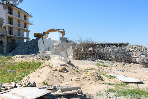 Image of Excavator with hydraulic hammer dismantling a building