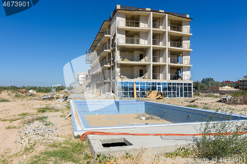 Image of Illegal construction on the coastal side, hotel demolition, unfinished swimming pool in the foreground