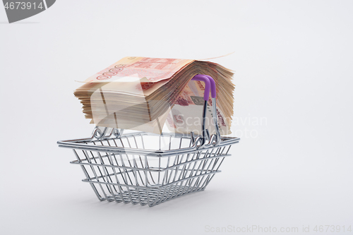 Image of On the handles of the grocery basket is a large bundle of paper Russian five-thousandth bills