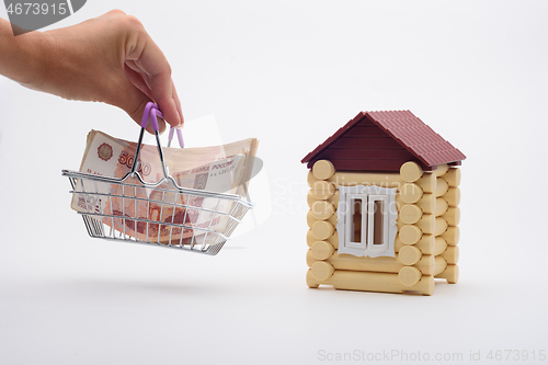 Image of A hand brings a basket with a bundle of Russian five-thousandth bills to the house