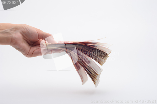 Image of Hand holds out a wad of money, white background