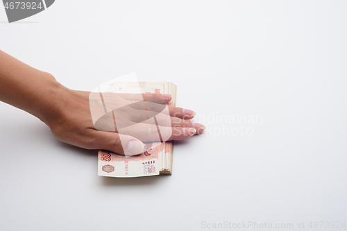 Image of The hand covered a stack of five thousandth bills on top