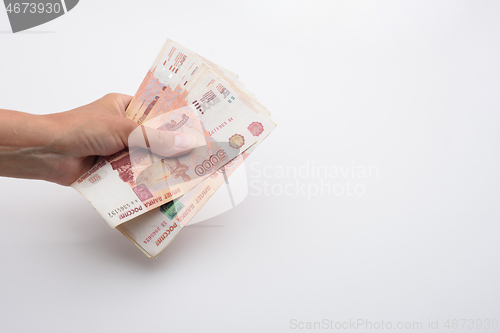 Image of Hand holds a bundle of Russian five thousandth bills