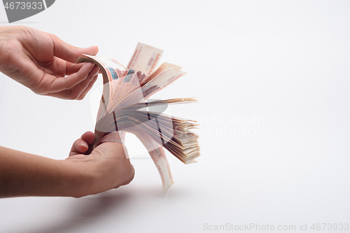 Image of Hand fan counts a wad of money, white background