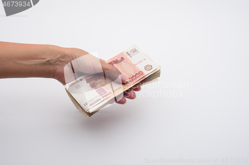 Image of Hand holds out a stack of five thousandth bills