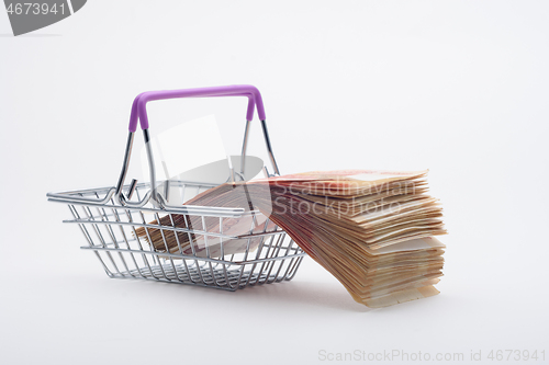 Image of There is a large stack of bills on a grocery basket, viewed from the side