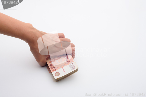 Image of Hand takes from a white background a pack of five thousandth bills