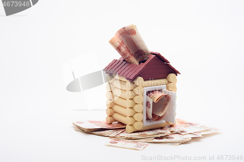 Image of Five-thousandth Russian banknotes stick out from the windows and the door of the house, the house stands on a bundle of banknotes