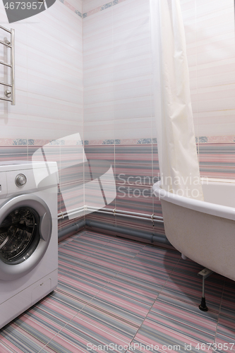 Image of View of an empty corner in the bathroom, with a washing machine and a bathroom on the sides