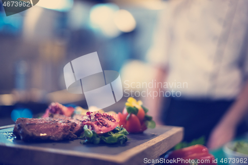 Image of Juicy slices of grilled steak on wooden board