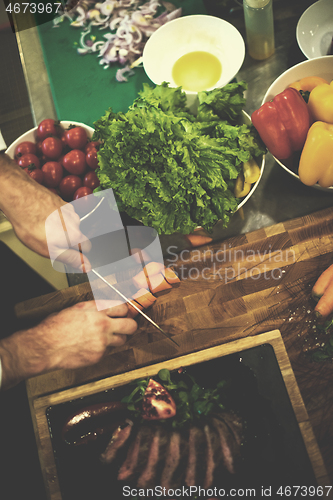 Image of top view of Chef hands serving beef steak