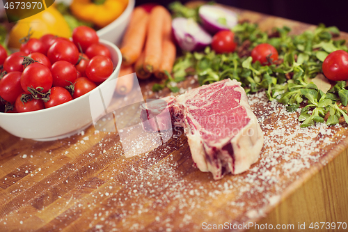 Image of Juicy slice of raw steak on wooden table