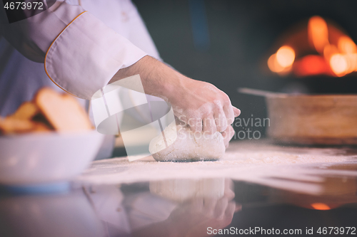 Image of chef hands preparing dough for pizza