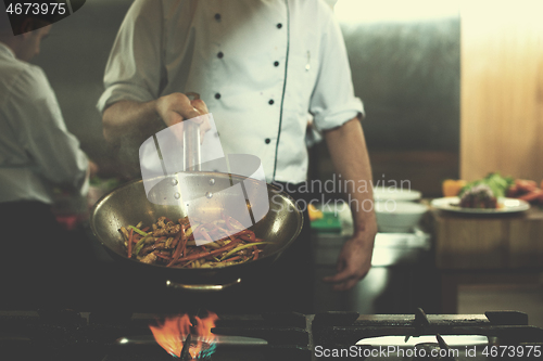 Image of chef flipping vegetables in wok