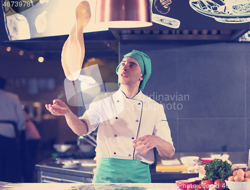 Image of chef throwing up pizza dough