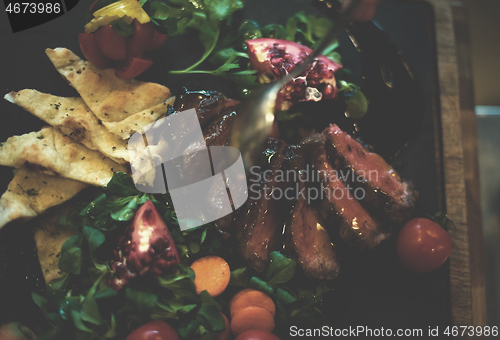 Image of Chef hand finishing steak meat plate