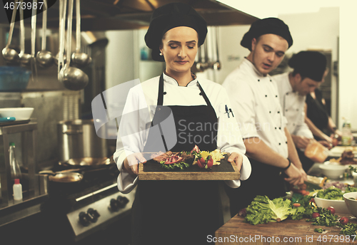 Image of female Chef holding beef steak plate