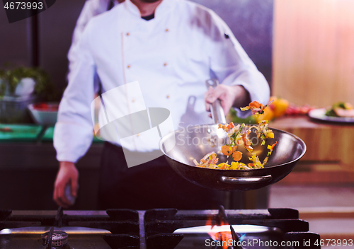 Image of chef flipping vegetables in wok