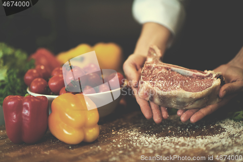 Image of Chef holding juicy slice of raw steak