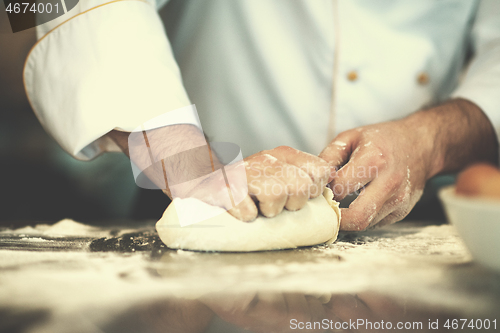 Image of chef hands preparing dough for pizza