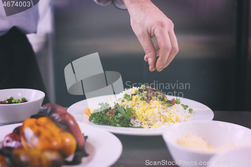 Image of Chef hands serving vegetable risotto