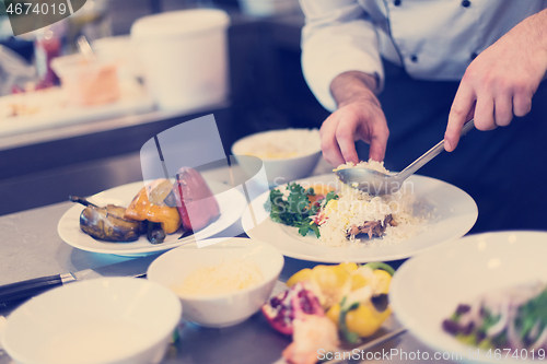 Image of Chef hands serving vegetable risotto