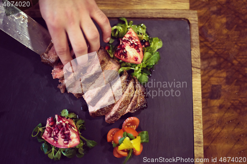 Image of top view of Chef hands serving beef steak