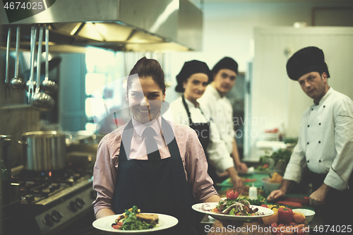 Image of young waitress showing dishes of tasty meals